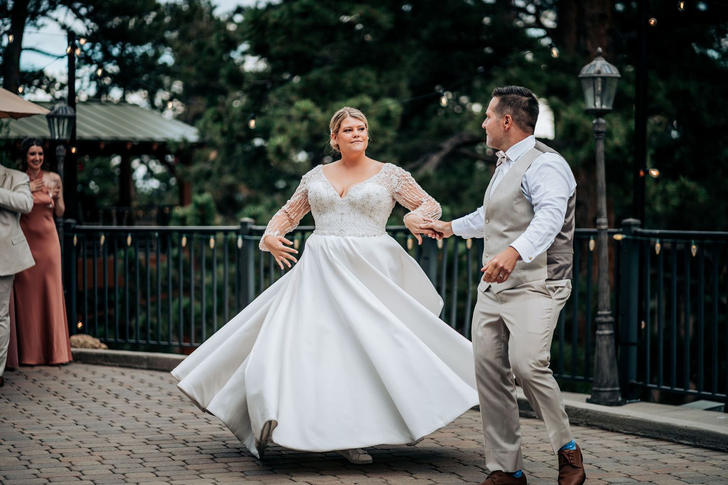 A bride in a flowing white gown twirls on the dance floor during her wedding celebration.