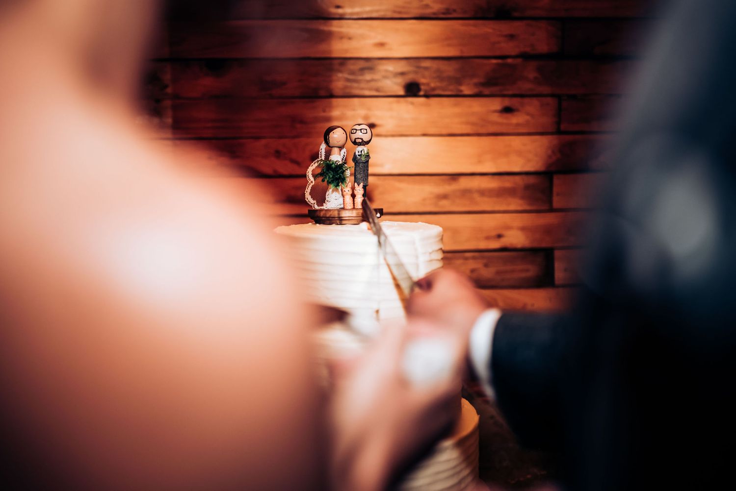 Decorative wedding cake topper being displayed against rustic wooden backdrop.