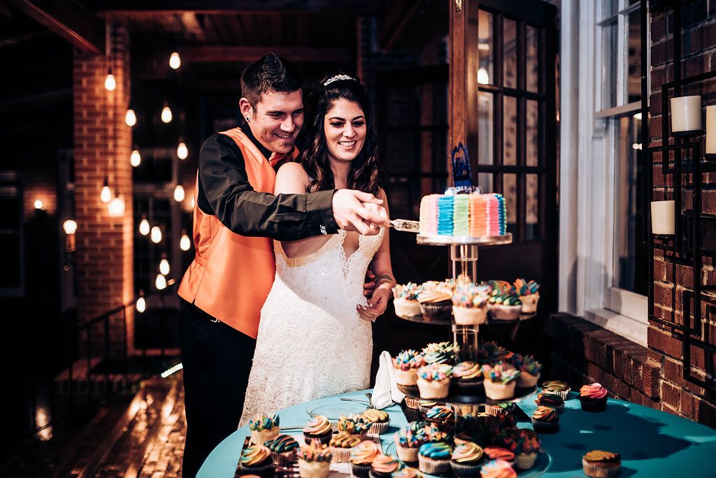 Wedding couple cutting their cake together at the dessert table display.