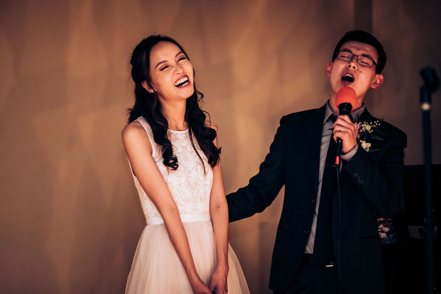 A joyful moment captured during wedding entertainment with bright stage lighting.