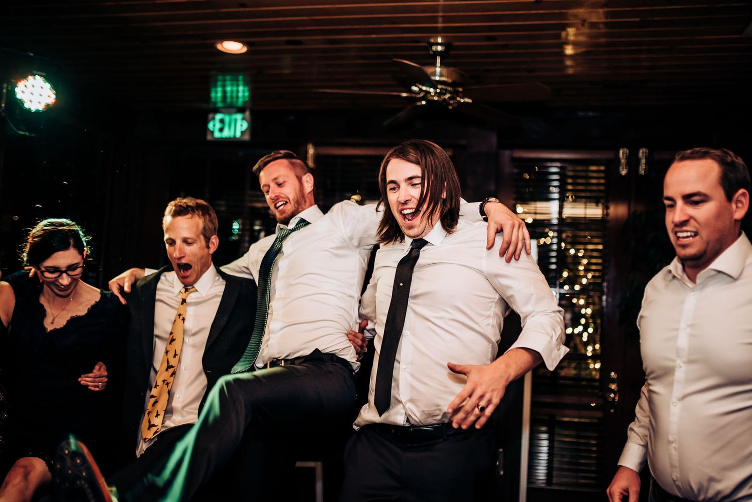 Group of formally dressed guests dancing and celebrating at a nighttime event.