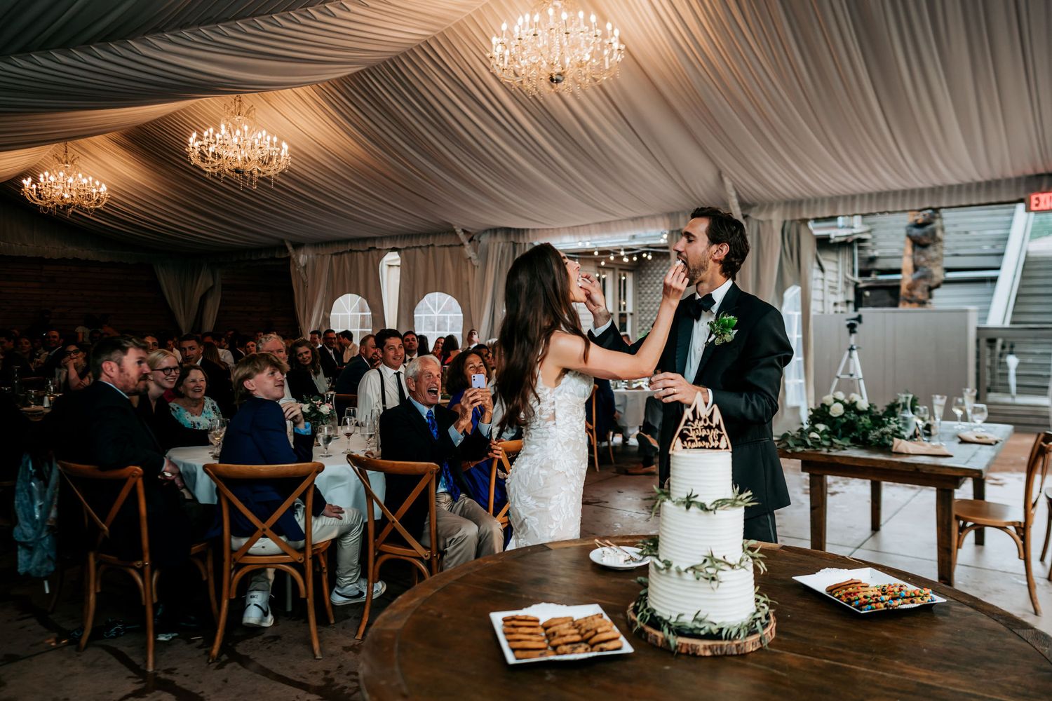 Newlyweds share a celebratory moment while cutting their multi-tiered white wedding cake.