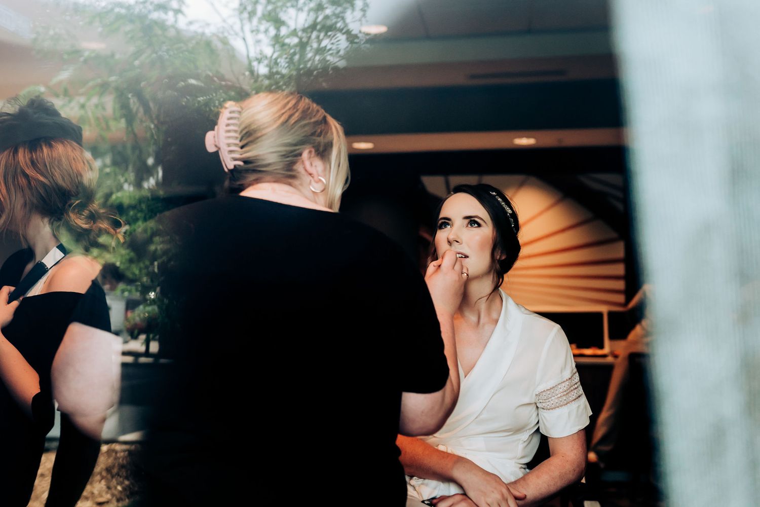 Candid moment captured during wedding preparation indoors.