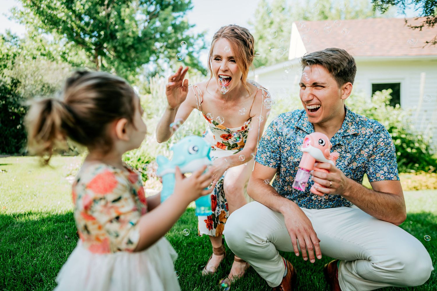 A joyful outdoor gathering with people playing and laughing on a sunny lawn.