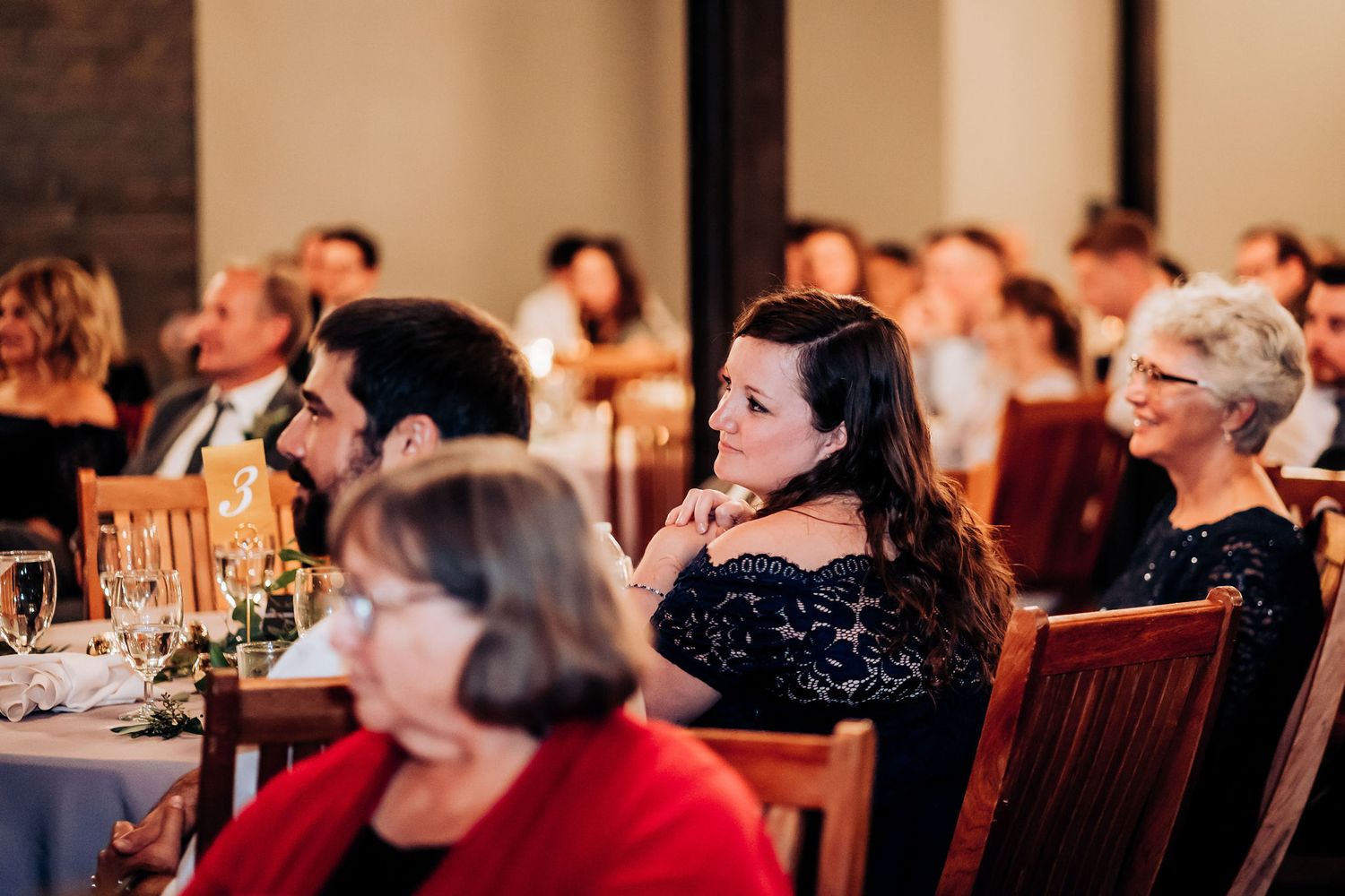 Wedding guests enjoying reception dinner in historic brick building venue.