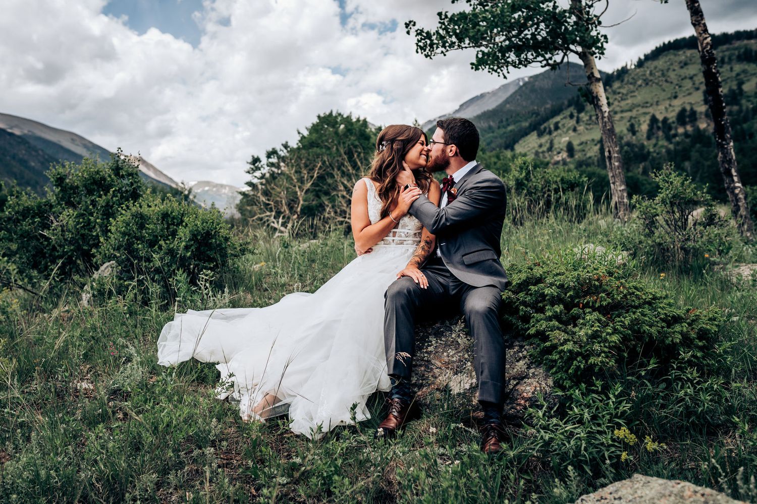A romantic wedding moment captured in a scenic mountain landscape.