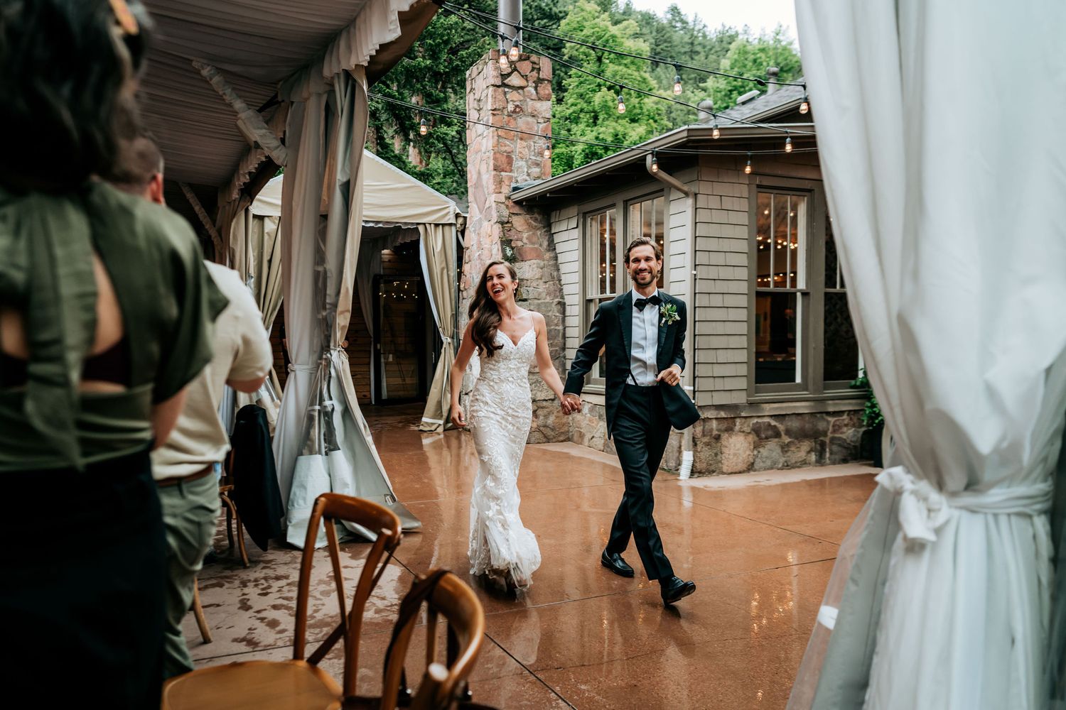 Couple dances between white drapes on outdoor patio during wedding reception.