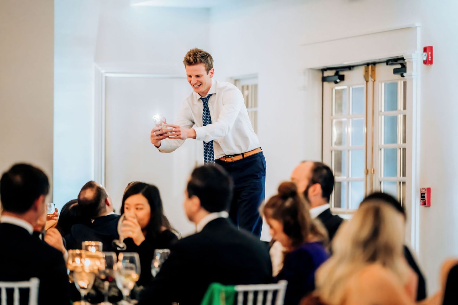Wedding guest entertains dinner crowd during reception speech.