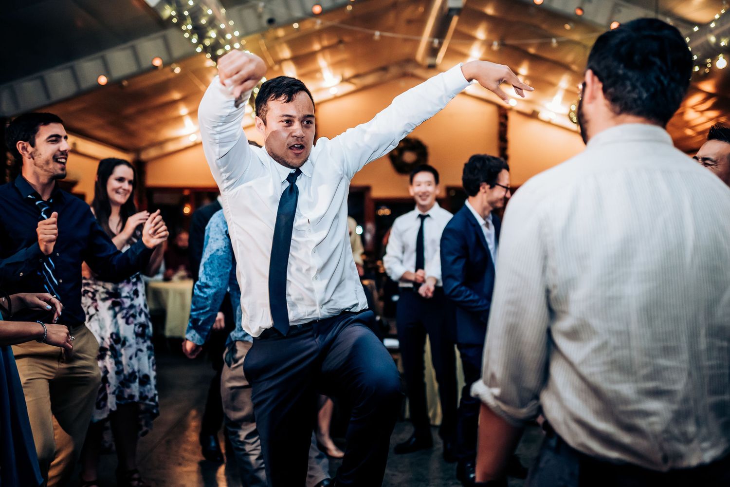 Energetic dancing at a wedding reception with guests celebrating on the dance floor.