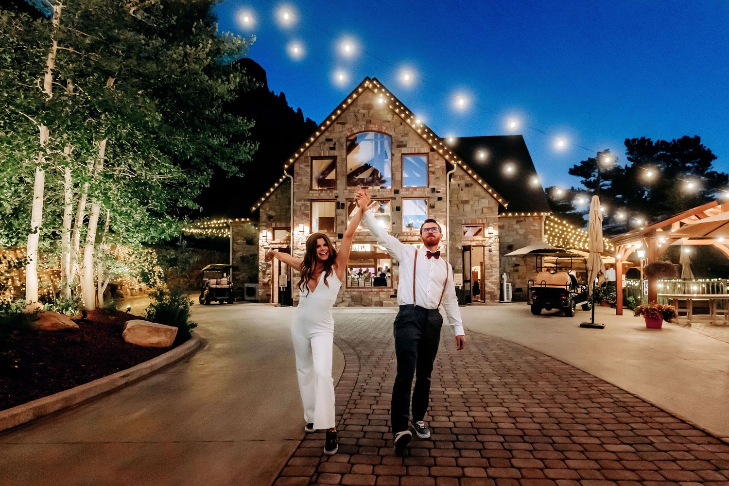 A rustic barn venue decorated with string lights creates a magical evening atmosphere.
