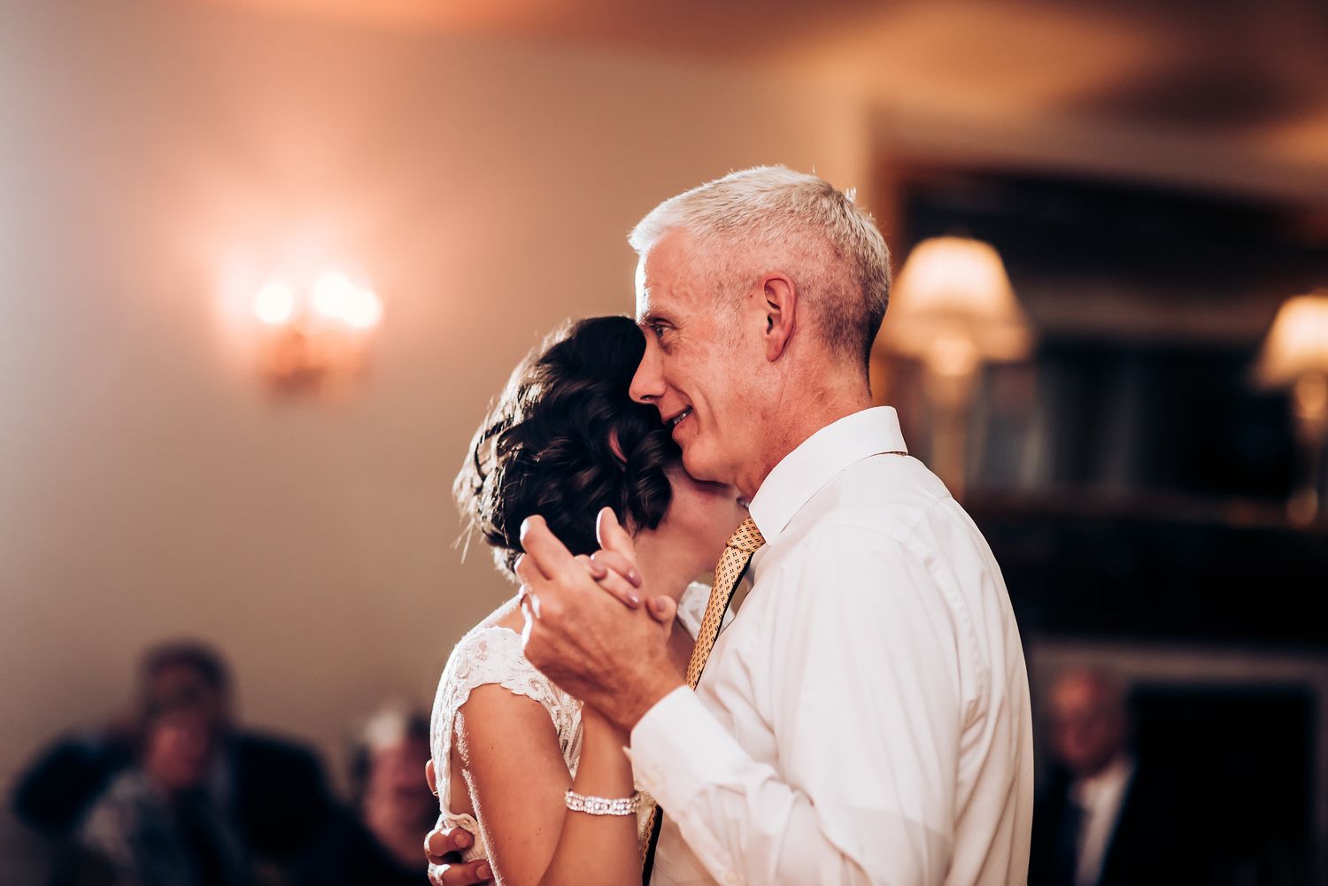 An intimate dance moment captured during a wedding reception with soft lighting.