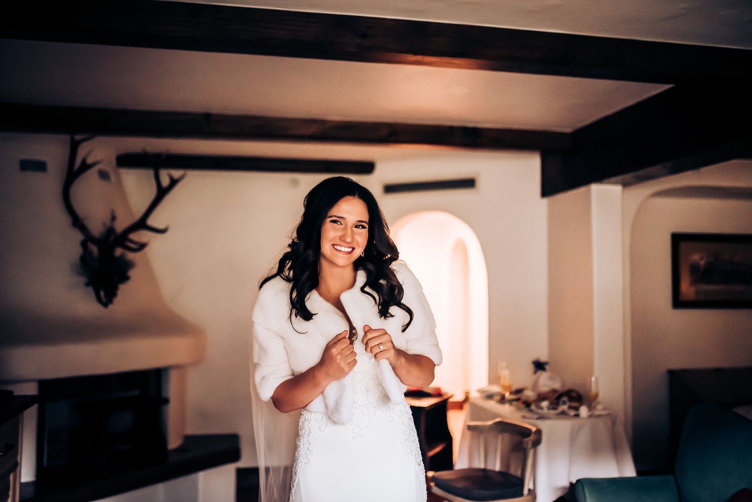 Elegant wedding preparations in a rustic room with mounted deer decor.
