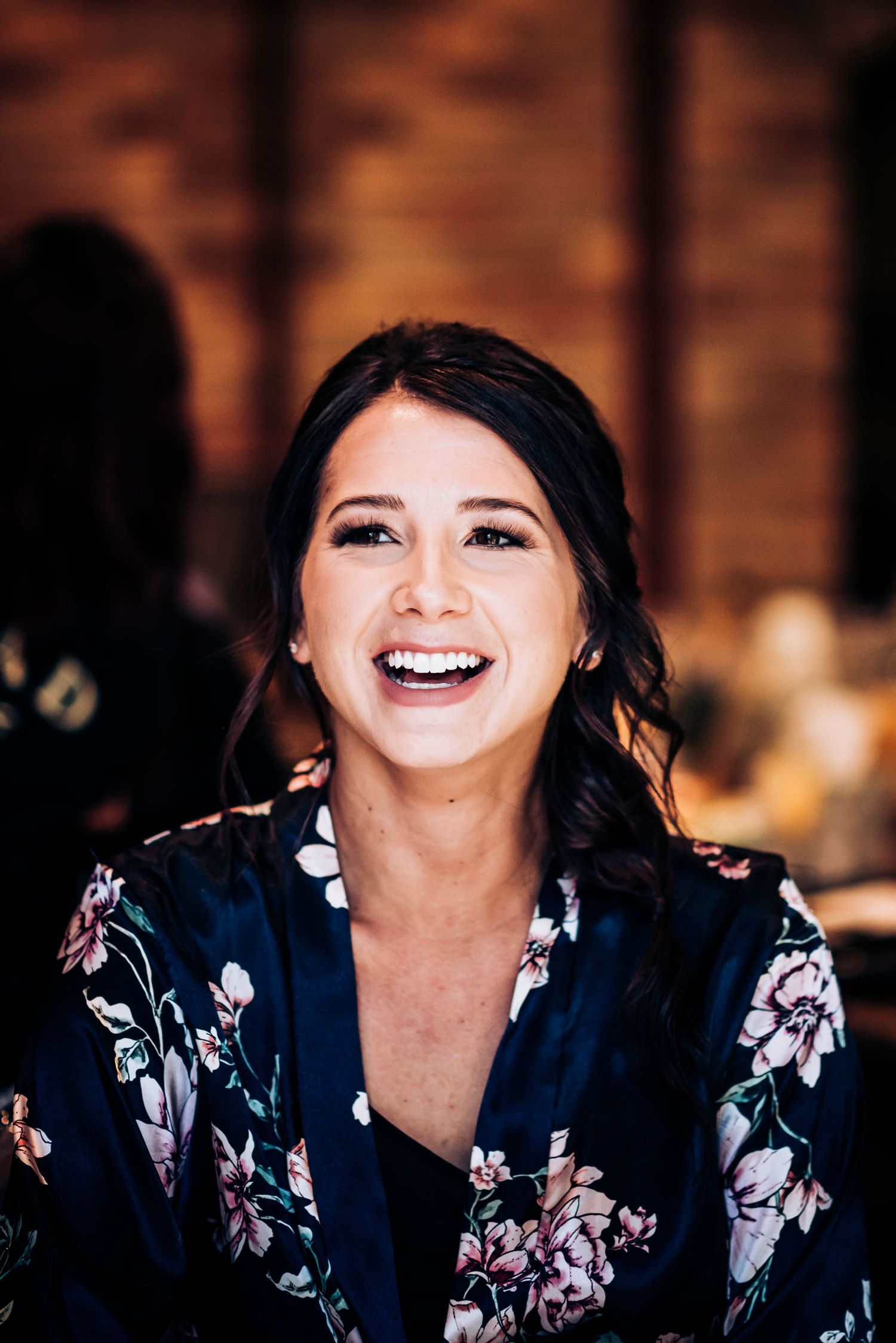 A joyful moment captured in a floral robe during wedding preparations.