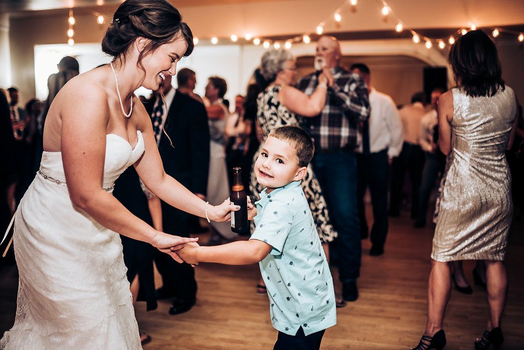 Dancing together at a wedding reception under soft lighting and decorative string lights.