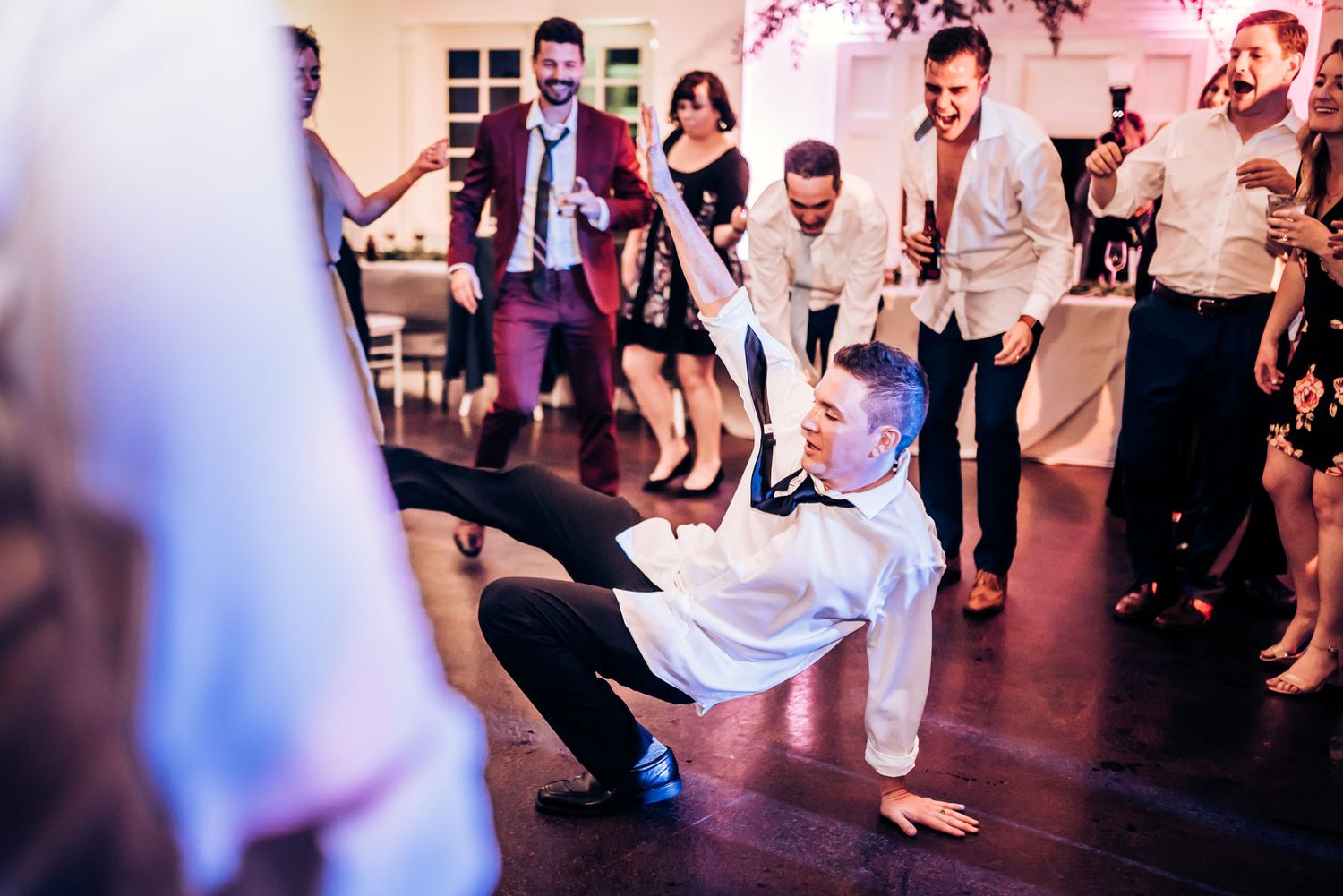 Wedding guests dancing and celebrating on the reception dance floor.