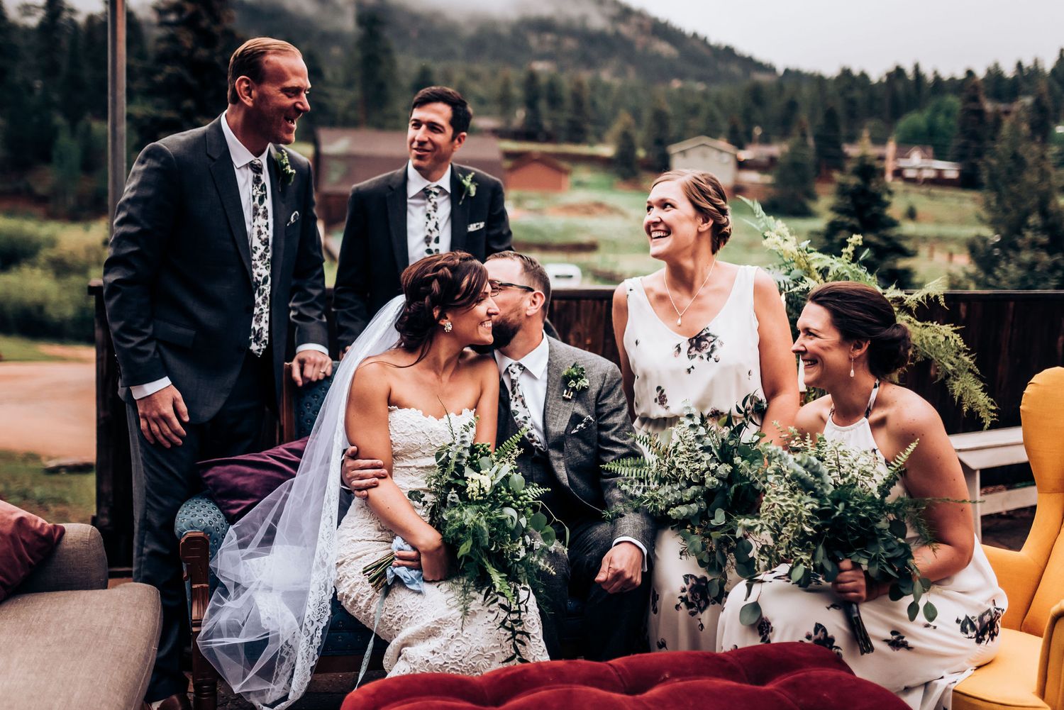 Wedding party shares joyful moment during outdoor mountain celebration.