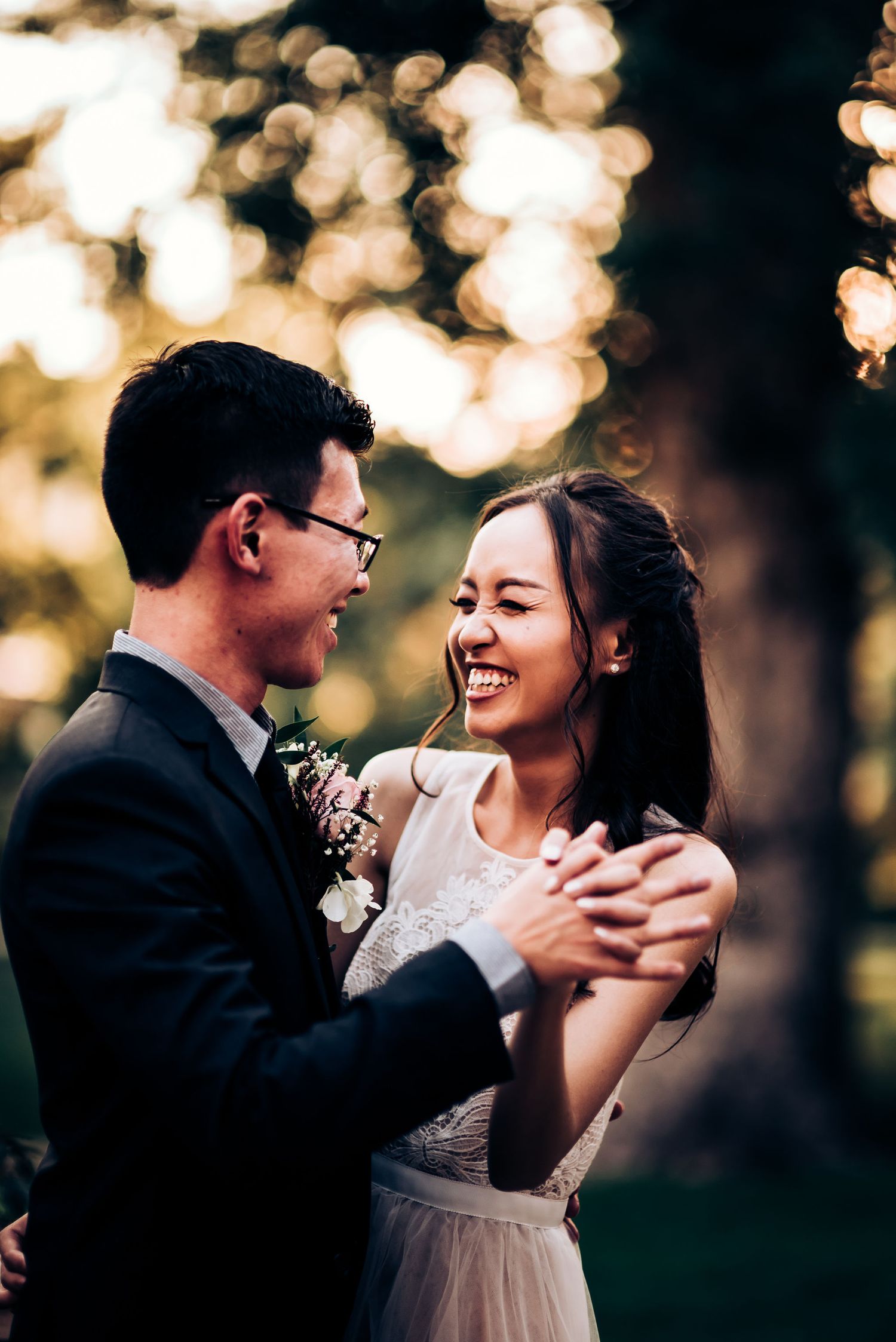 A joyful dancing couple share an intimate moment at sunset with beautiful bokeh lighting.