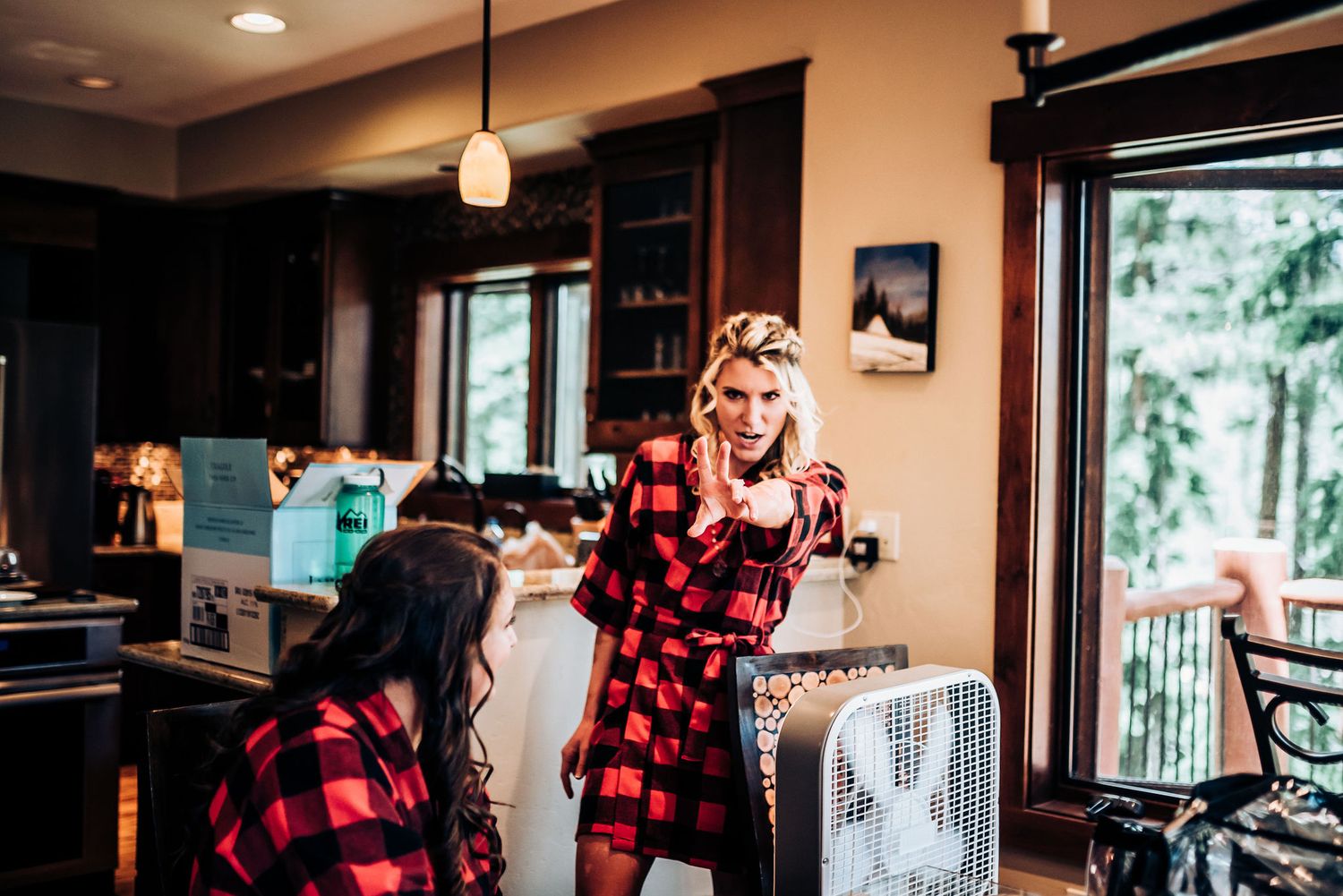 Side profile view of someone in a plaid shirt seated at a table indoors.