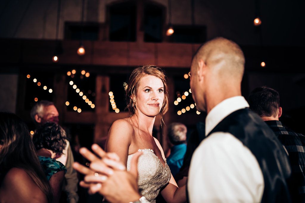 Dynamic dance floor moment captured during evening wedding reception celebrations.