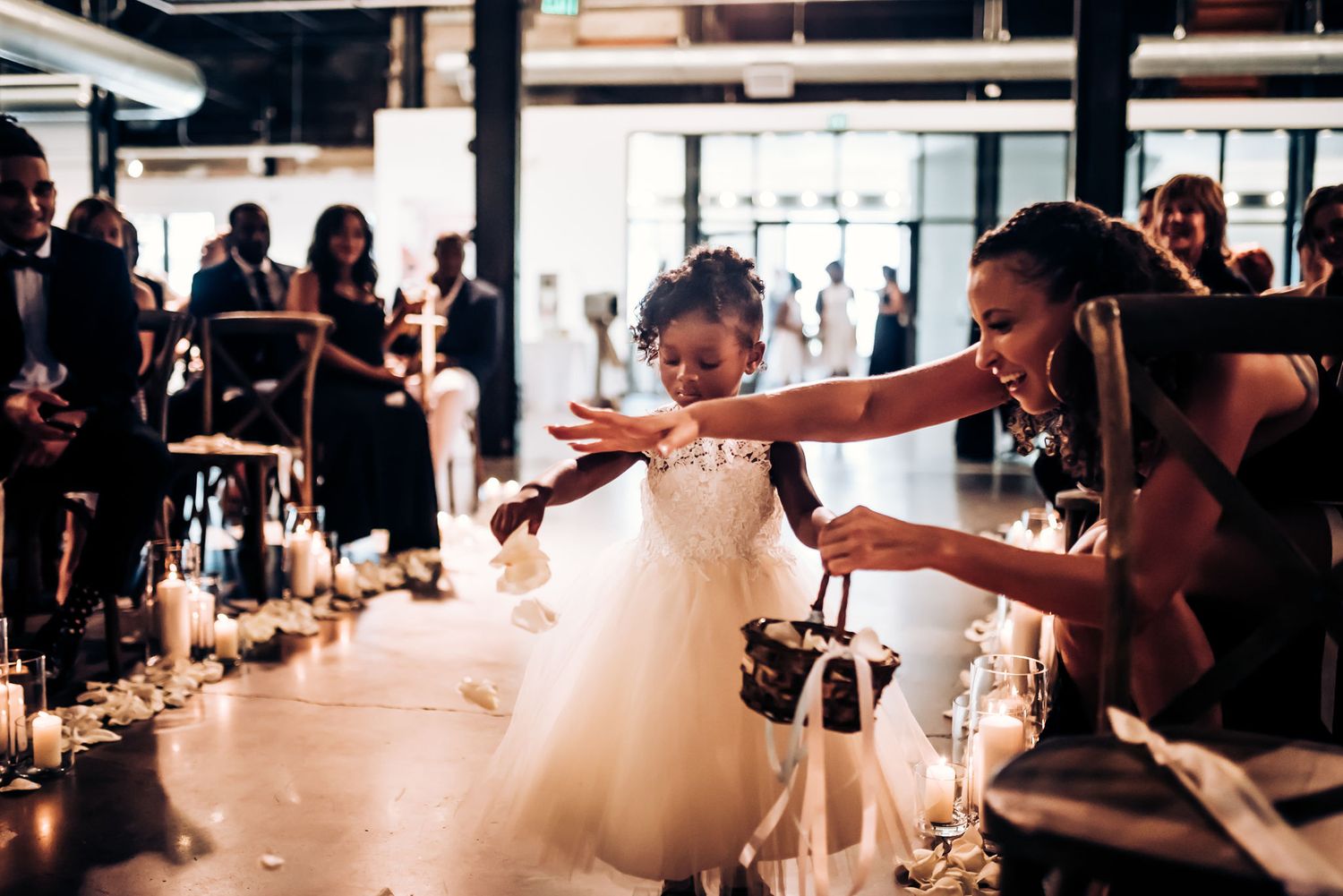 A young person in a white dress twirls joyfully on the dance floor at a wedding celebration.