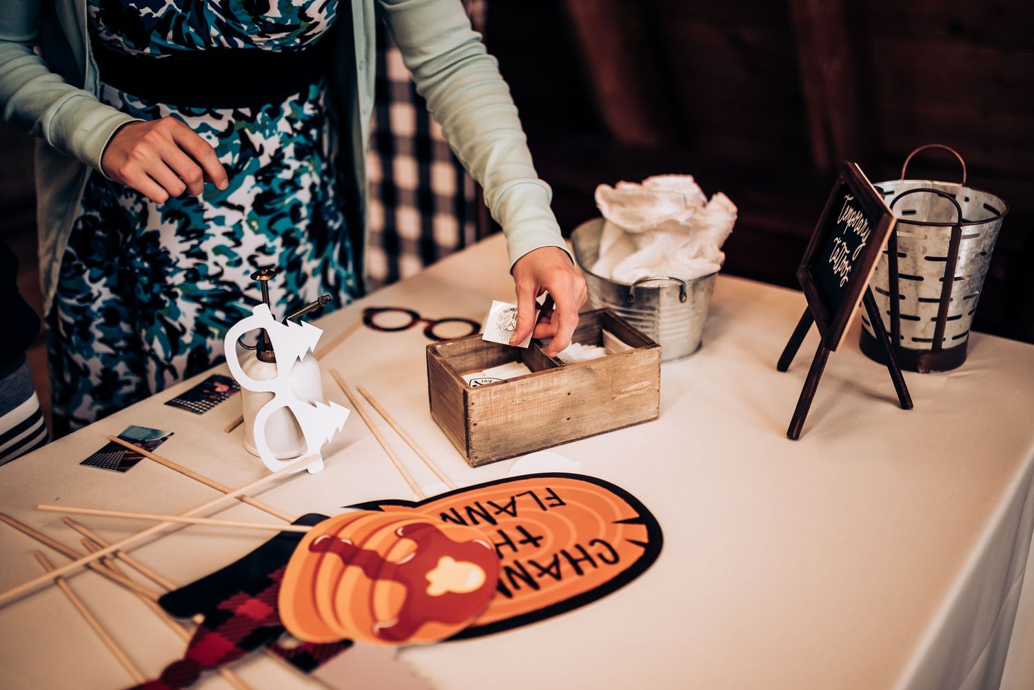 Close-up of table with party decor and supplies including a wooden box and Halloween themed items.