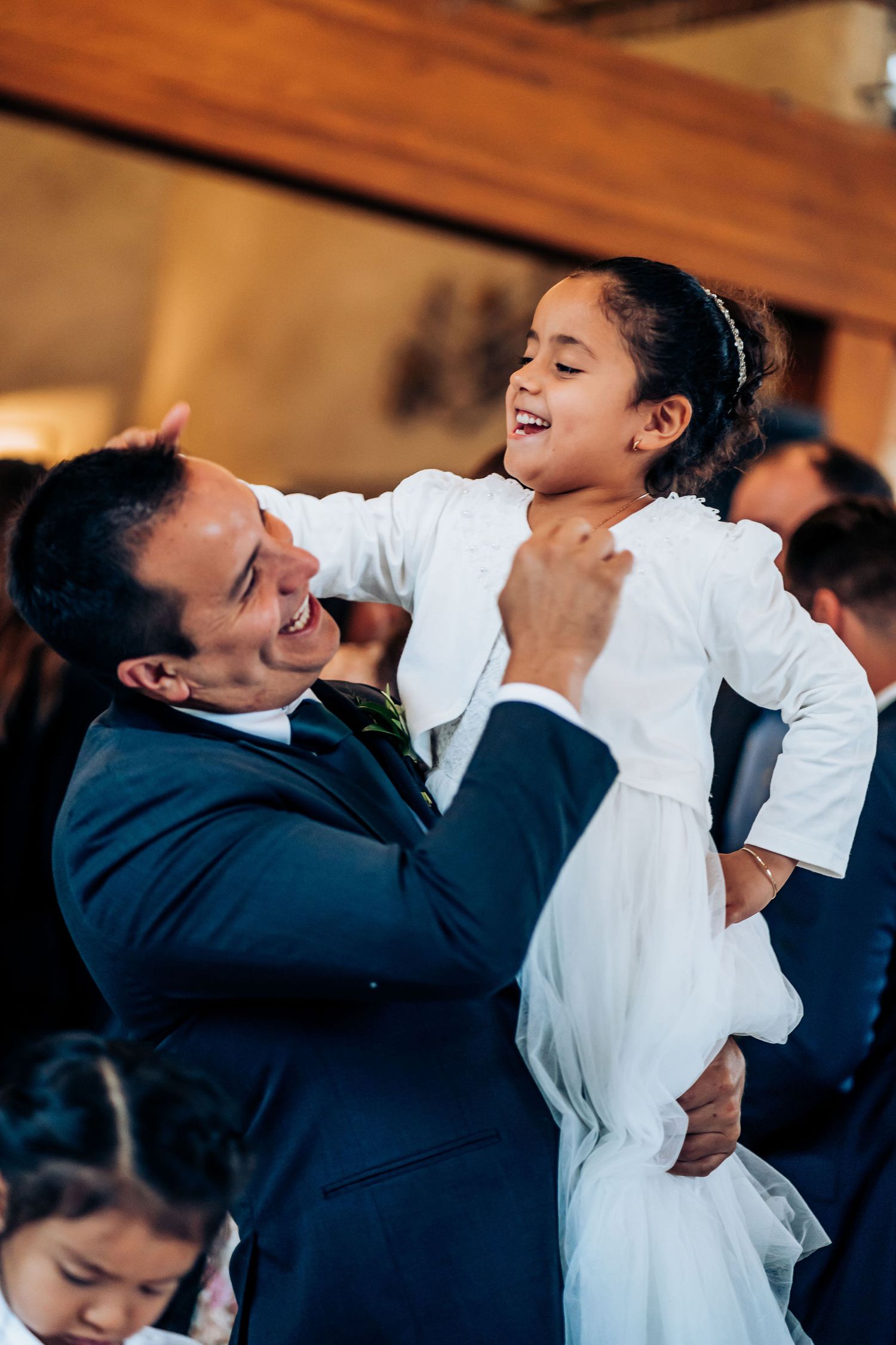 Joyful interaction between two wedding attendees in formal attire during celebration.