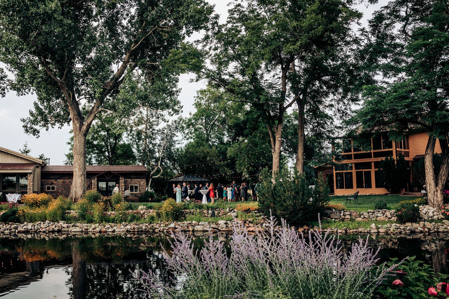A serene wedding venue with lavender gardens, reflecting pool and rustic lodge buildings.