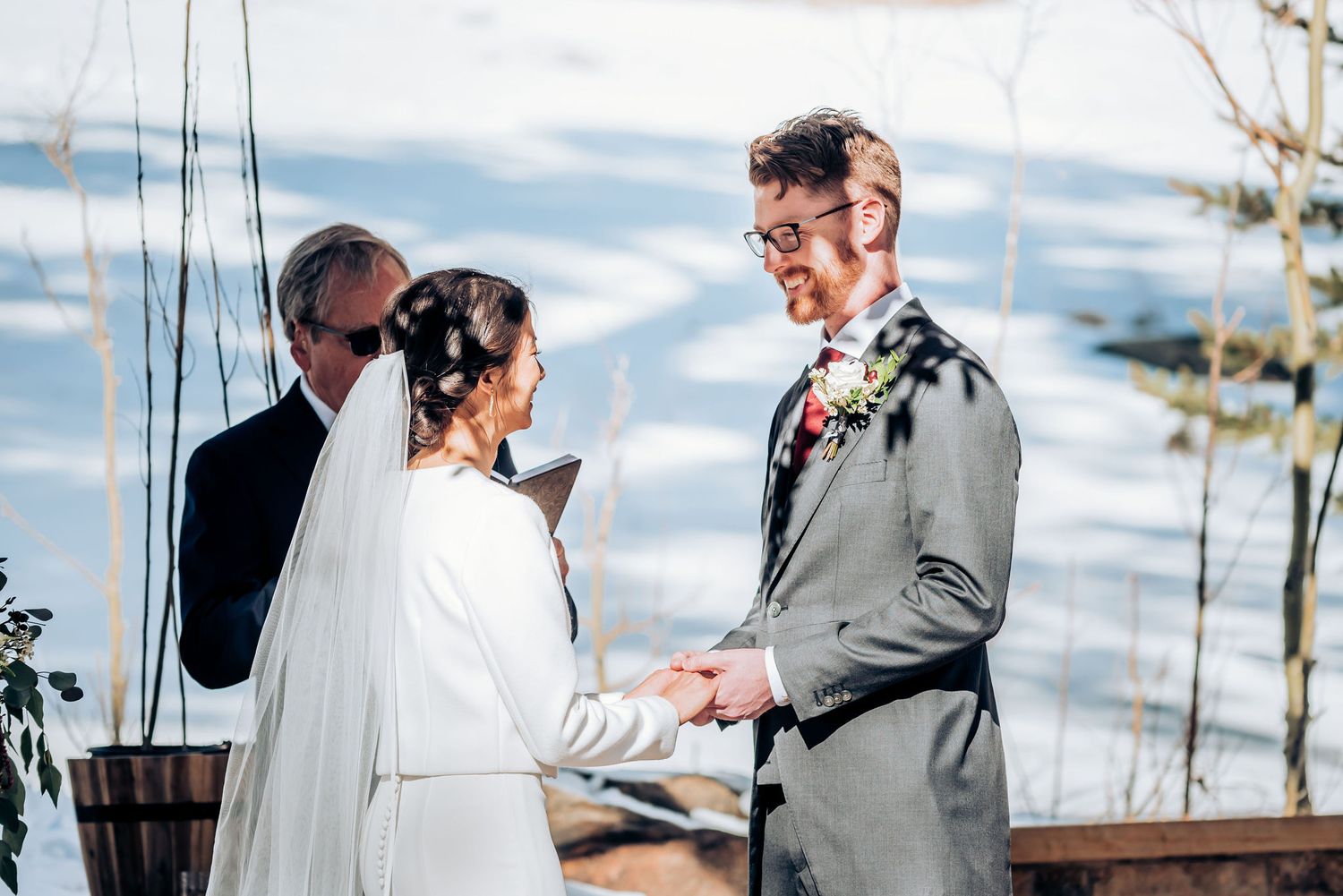 Ceremony exchange between couple during outdoor winter mountain wedding.