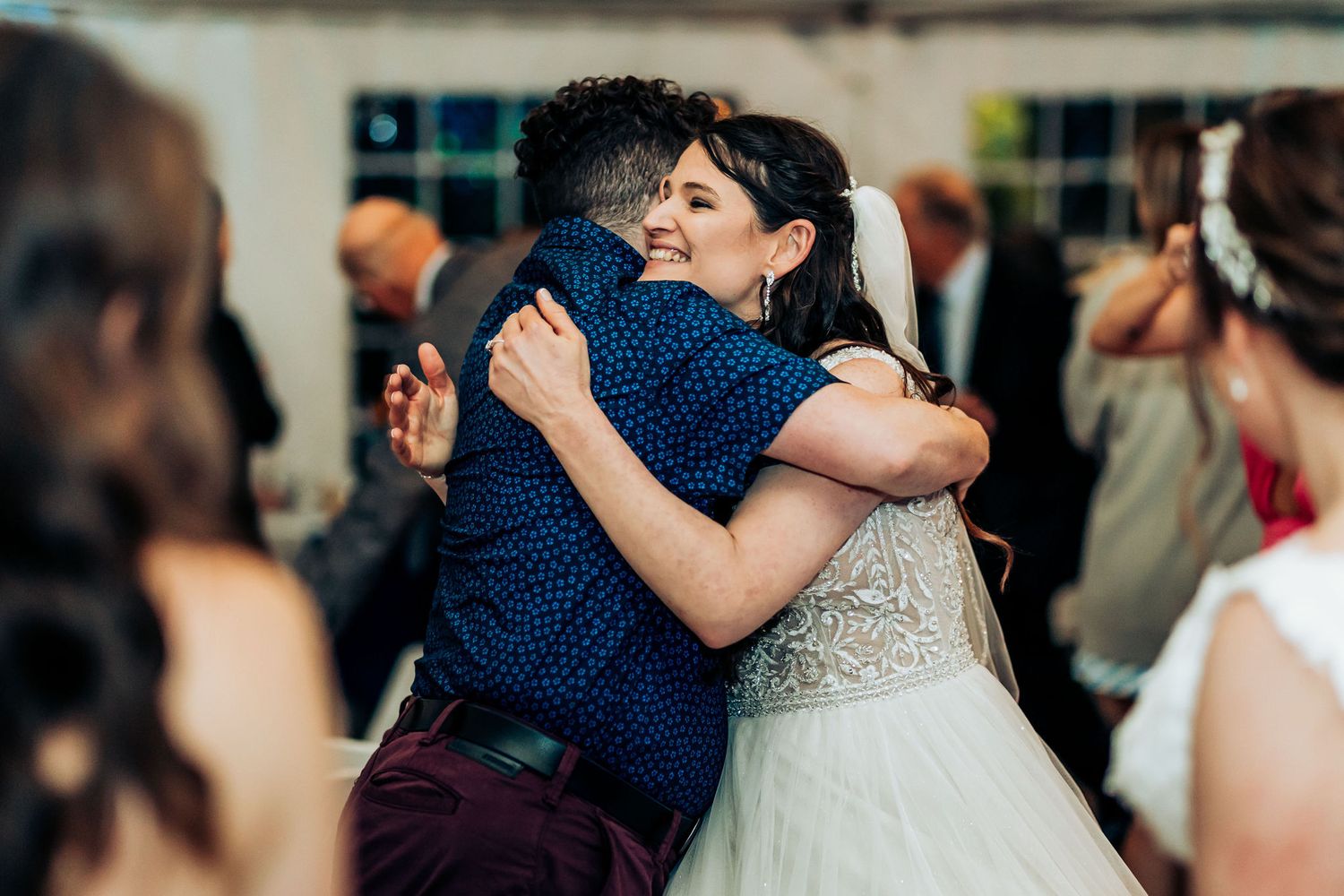 Heartfelt embrace during wedding reception celebration.