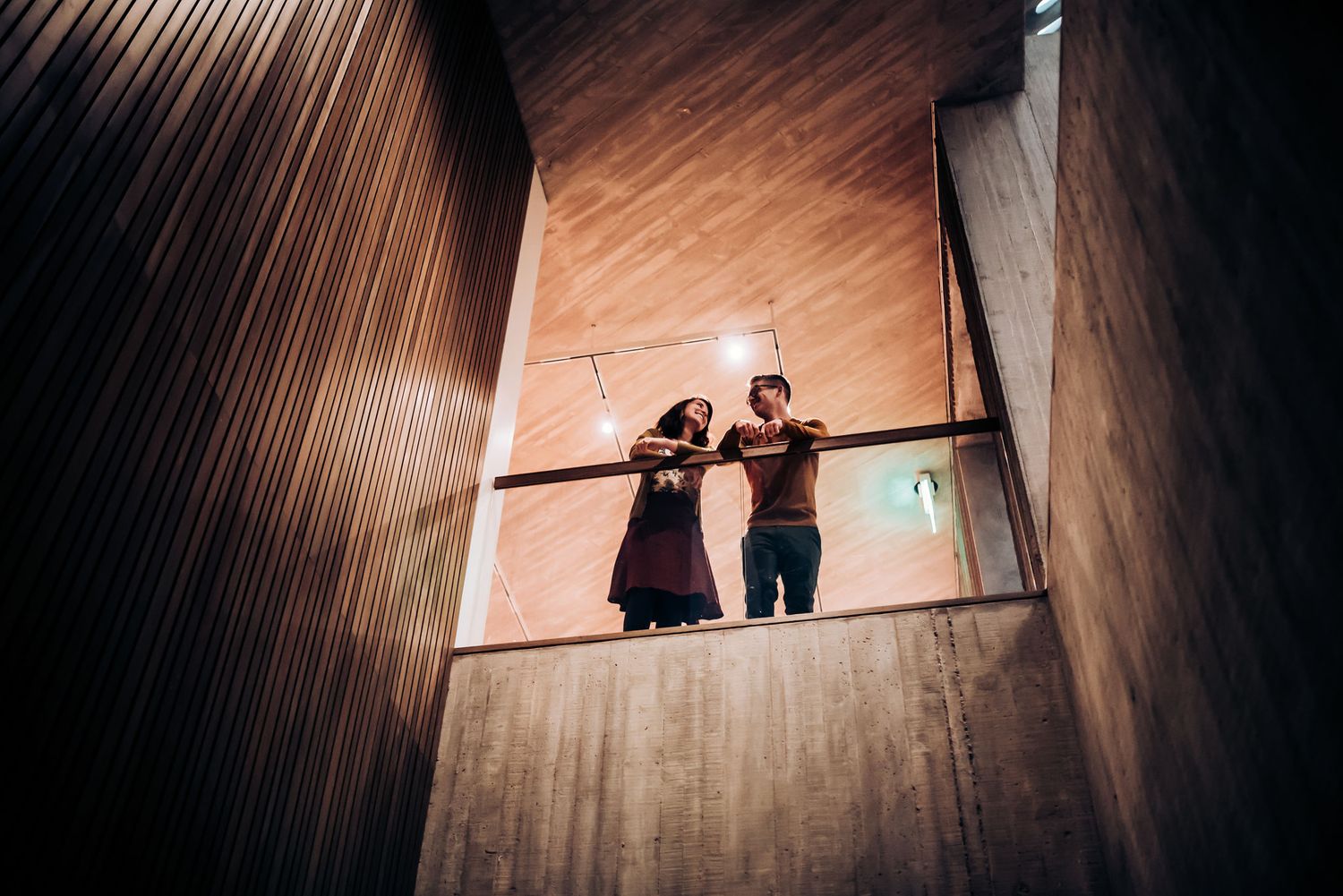 Intimate moment between couple in art gallery with gentle lighting.