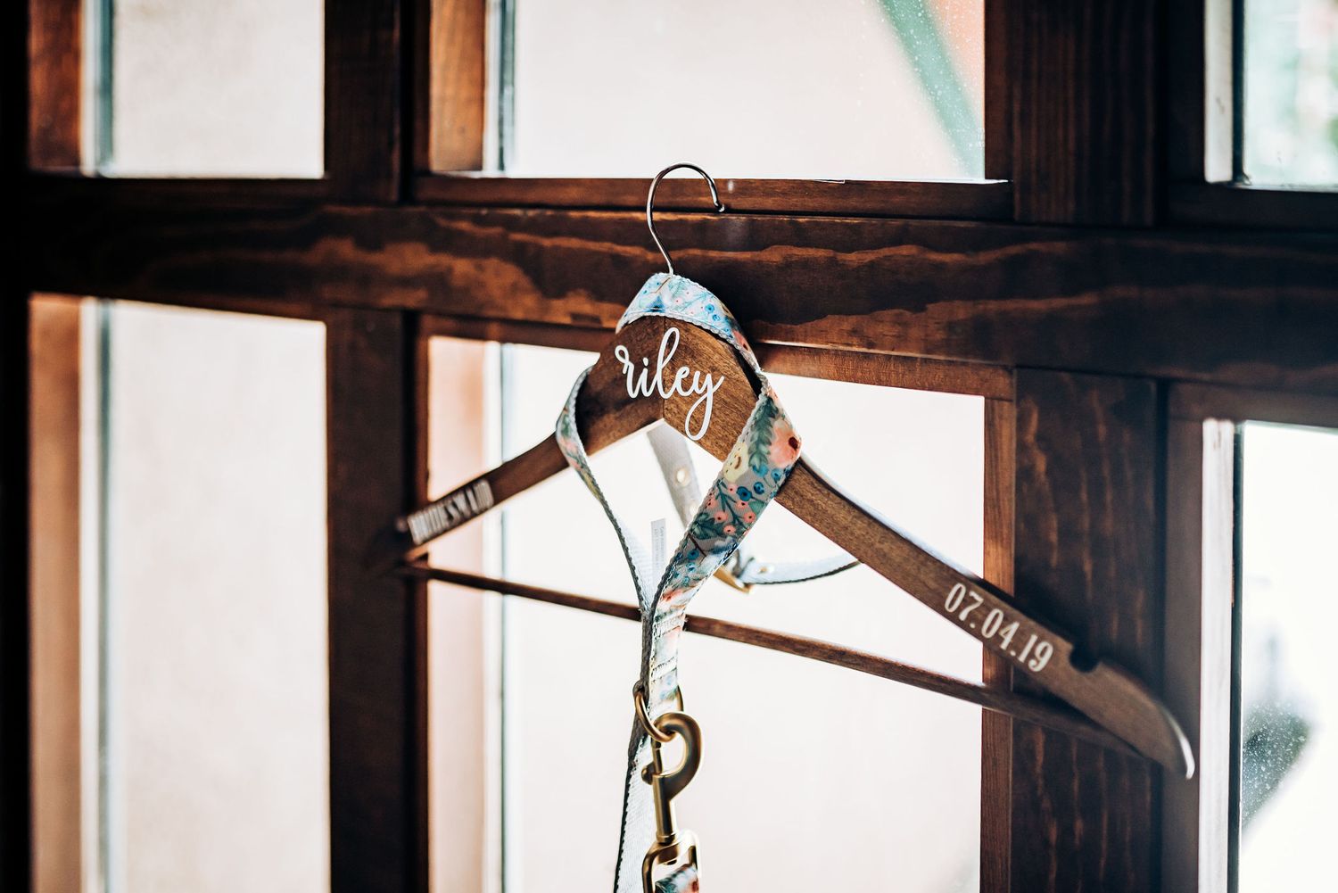 Custom wooden wedding hanger with text displayed in window frame.