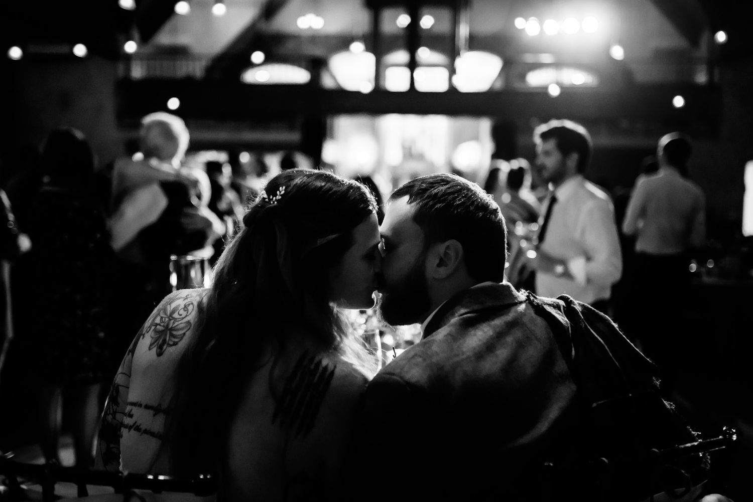 Close-up black and white photo of a couple's tender moment during an evening celebration.