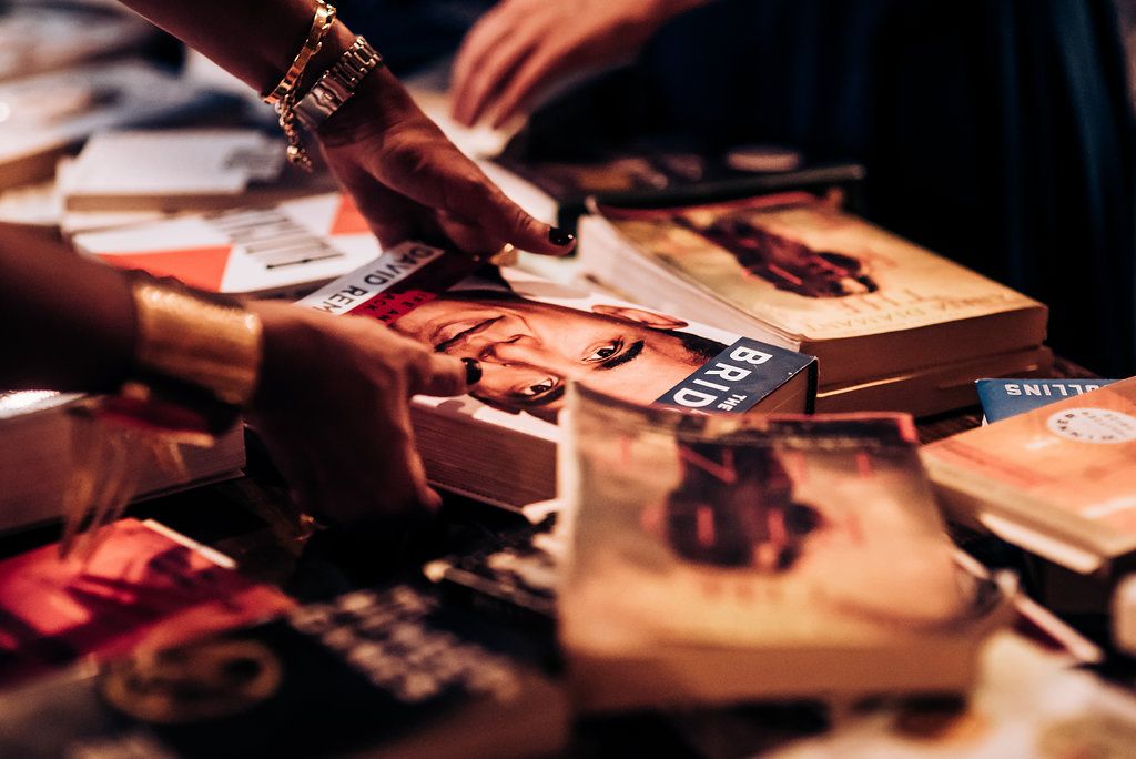 Close-up of books being signed at wedding guest book table.