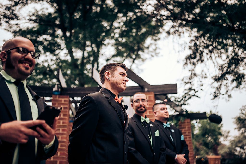Wedding party members in formal attire sharing a lighthearted moment outdoors.