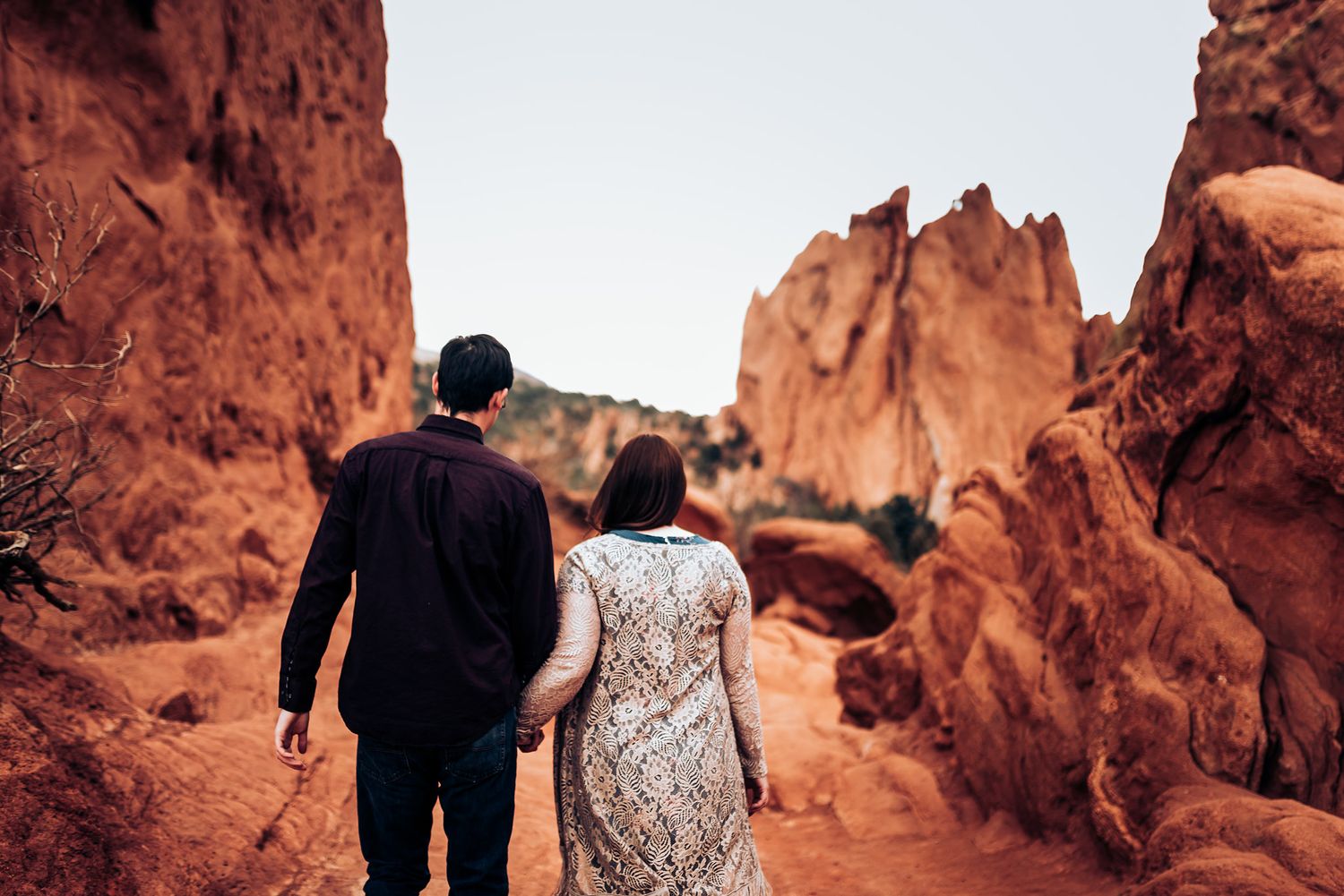 Couple walking through dramatic red rock formations at Garden of the Gods.