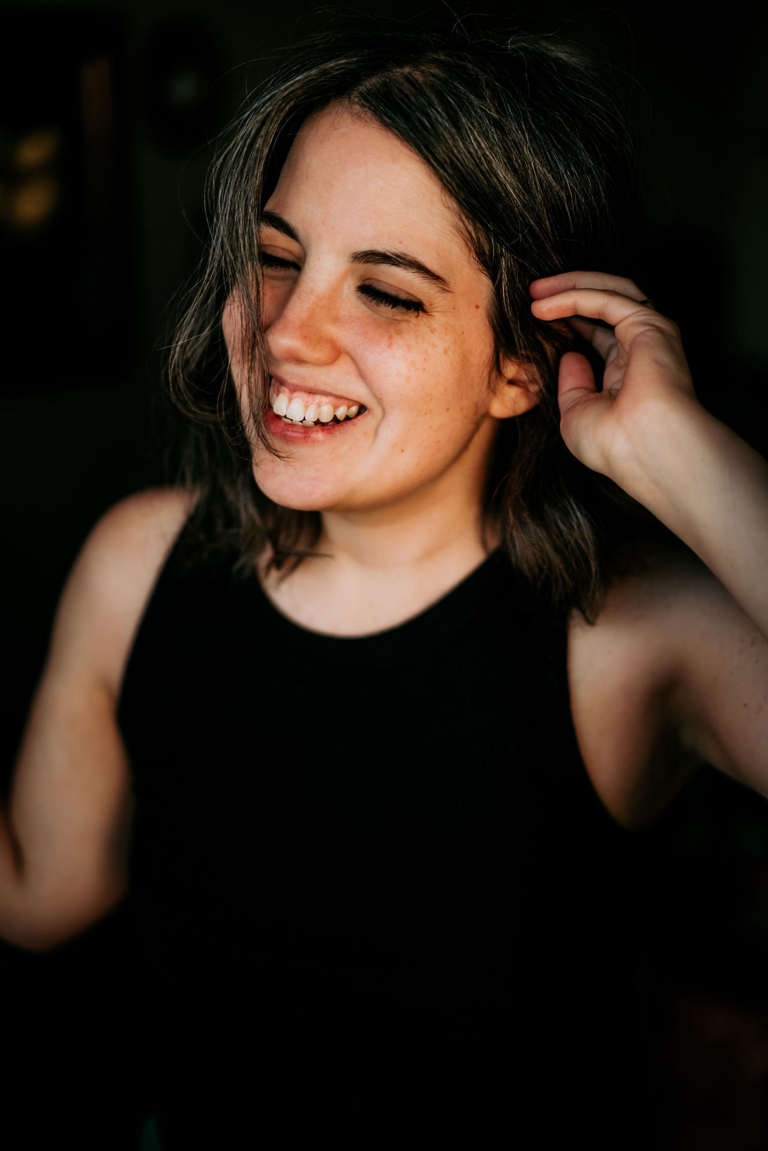 Candid moments of laughter captured in dark, intimate lighting.