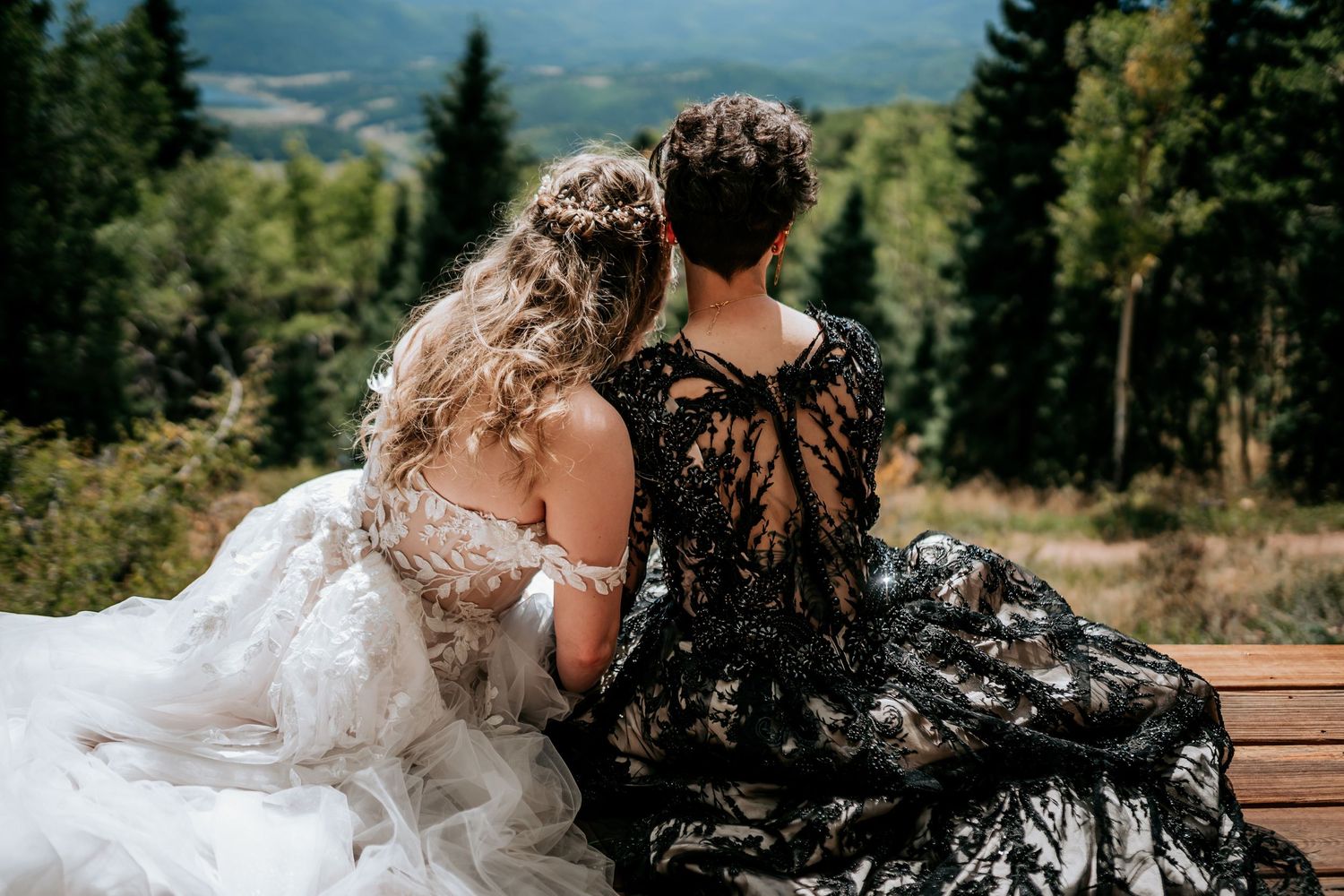Mountain landscape with evergreen trees creates dramatic backdrop for outdoor wedding ceremony.