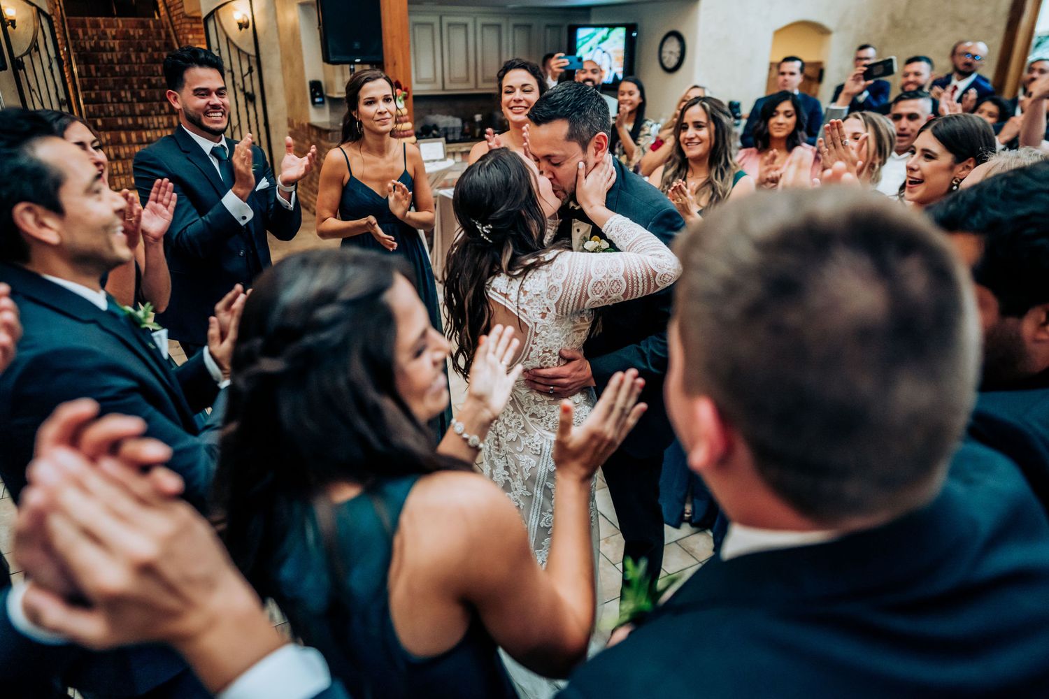 Wedding guests dancing and celebrating in a crowded reception venue.