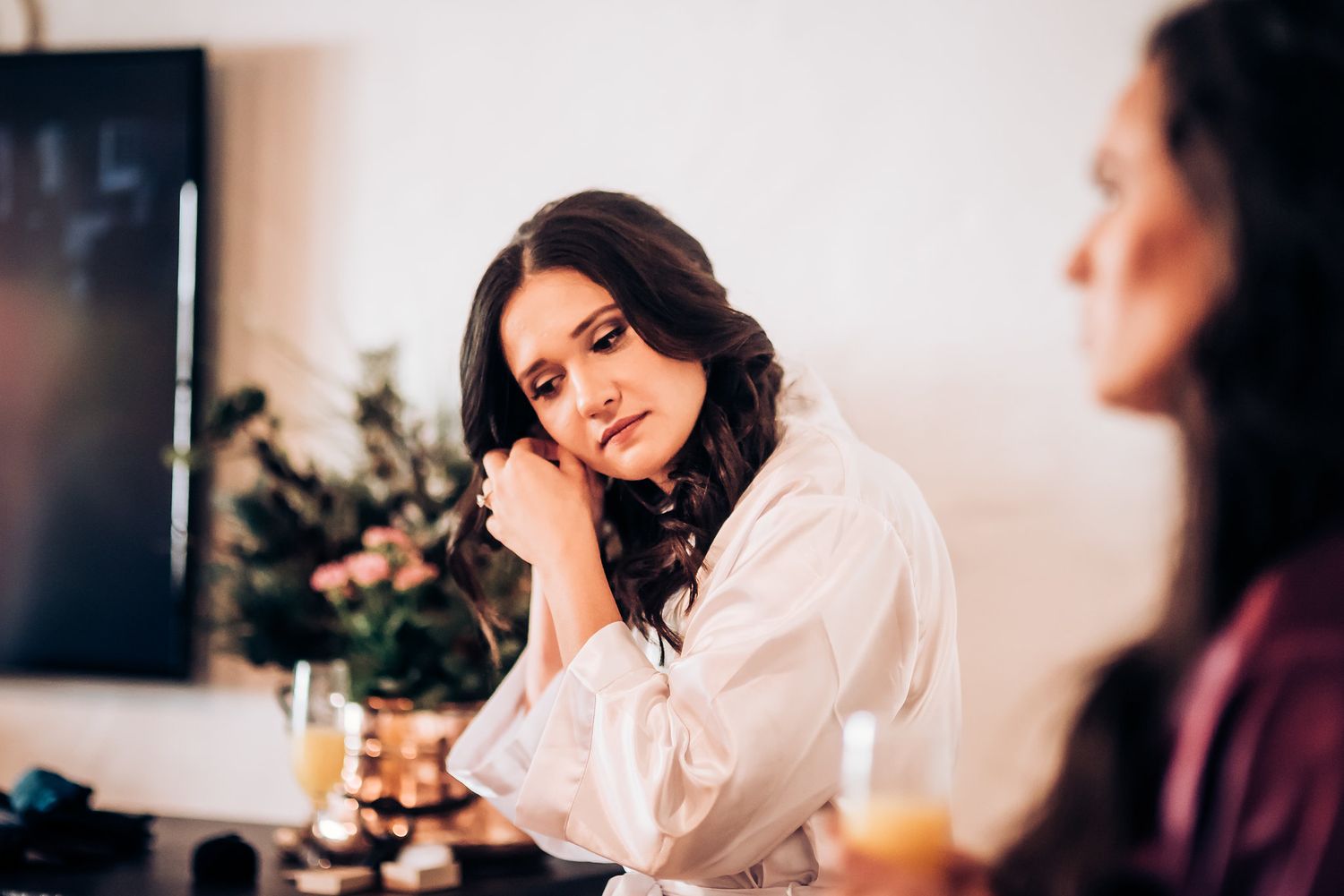 Wedding morning preparation scene with silk robes and floral arrangements.
