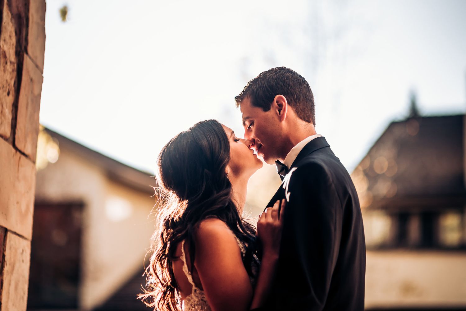 Intimate sunset portrait of wedding couple sharing romantic moment outdoors.