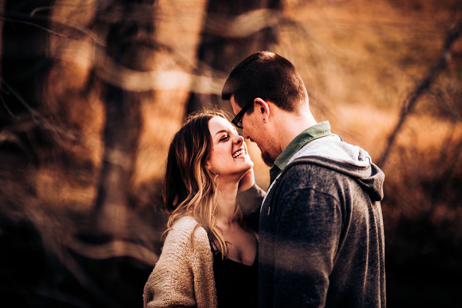 Close-up romantic moment between couple during autumn outdoor photoshoot.