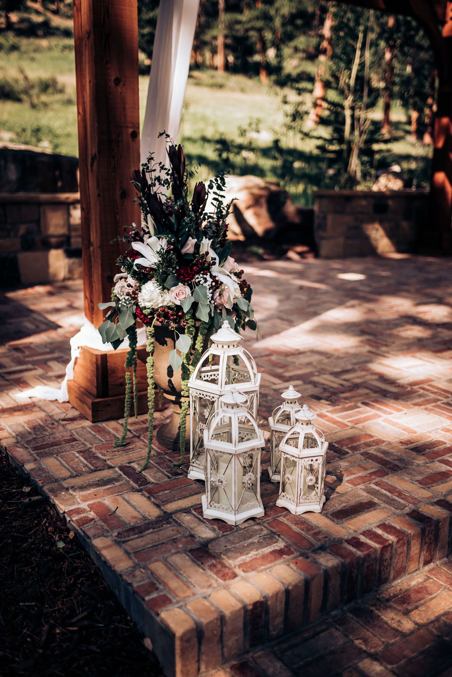 Elegant wedding decor featuring white lanterns and floral arrangements on a rustic brick surface.