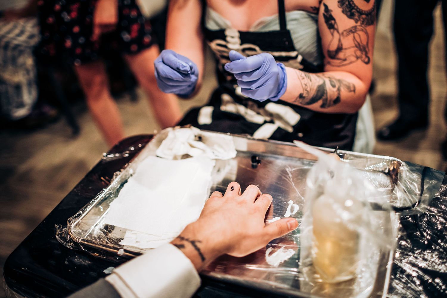 Tattooist preparing equipment for wedding ceremony tattoo service.