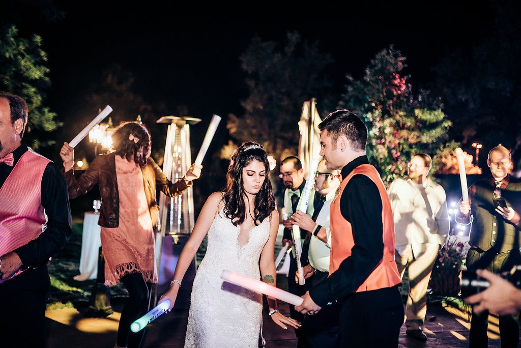 Wedding celebration at night with guests holding glowing sparklers creating a festive atmosphere.