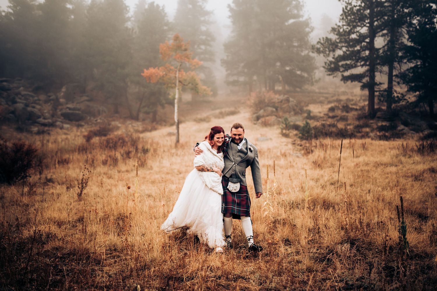 A wedding celebration on a foggy mountainside with autumn colors and pine trees.