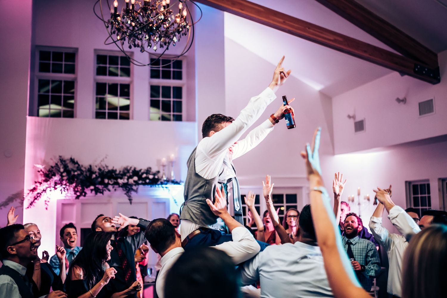 Celebratory moment with someone being lifted up during a lively party.