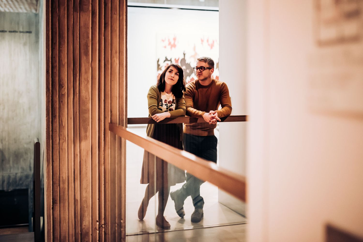 Two people ascending modern staircase with dramatic lighting.