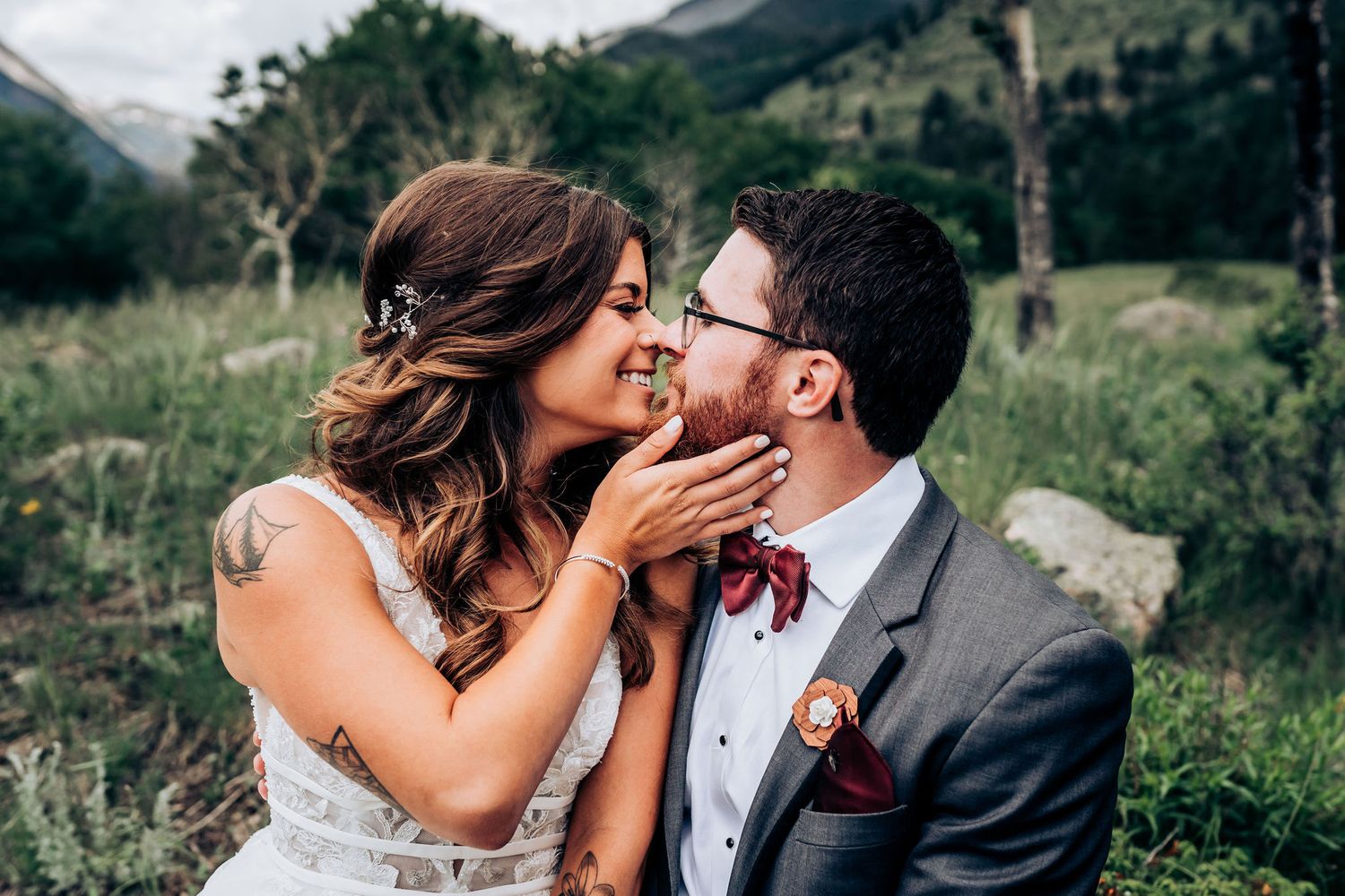 An intimate wedding kiss shared in a beautiful mountain setting.