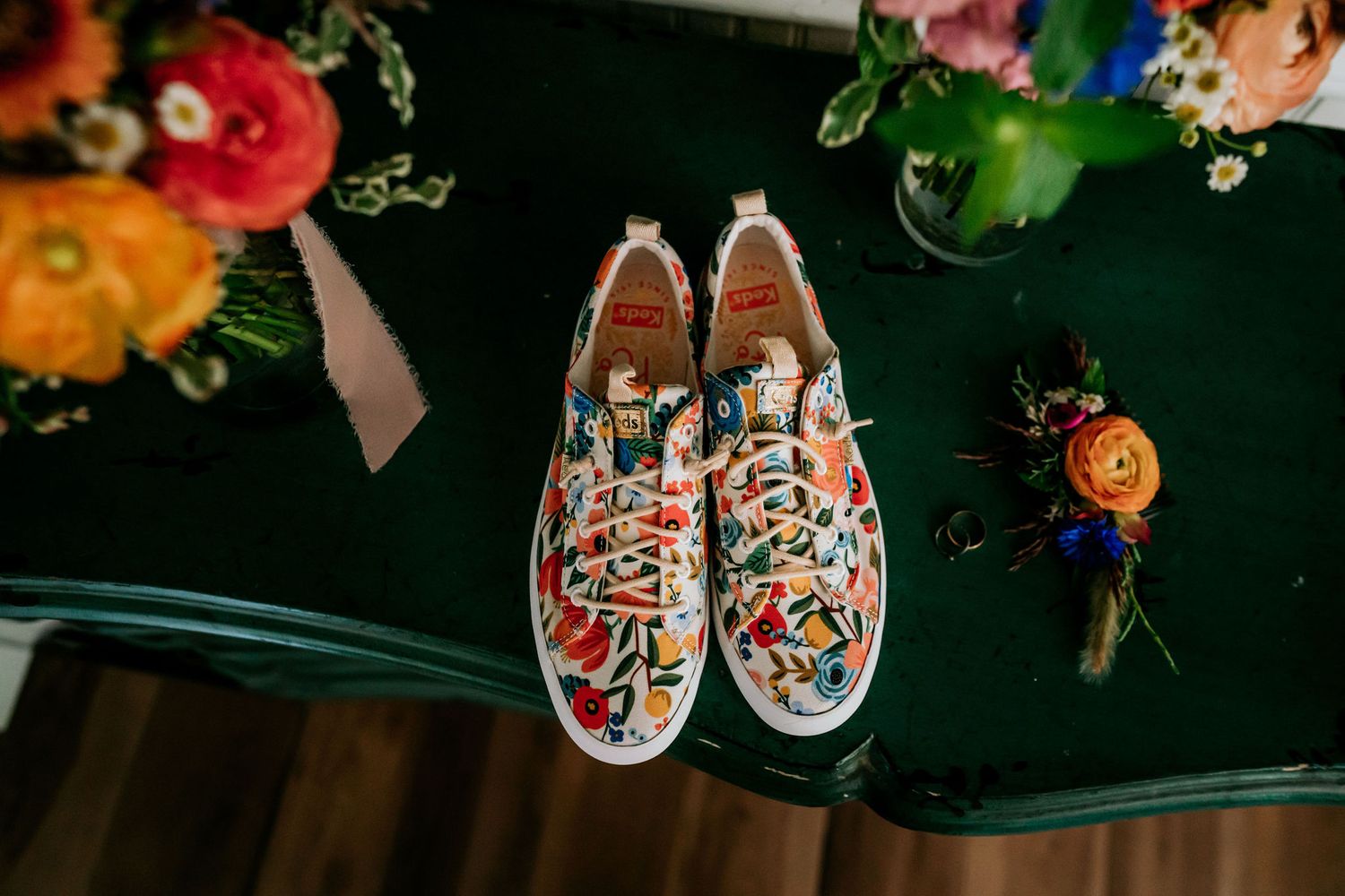 Floral patterned slip-on sneakers displayed with colorful flowers and decorative details.