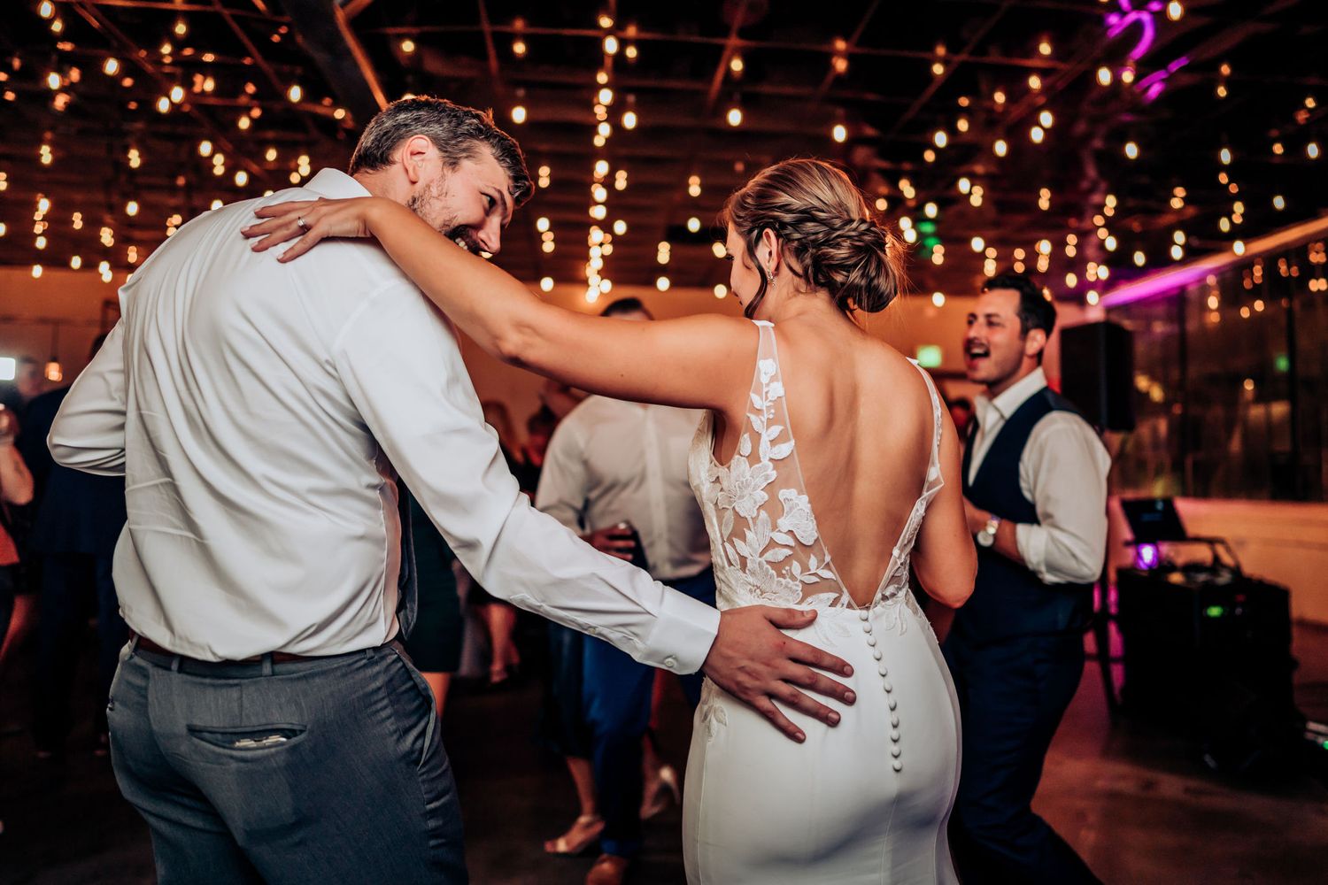 Couple sharing an intimate dance moment on the reception floor under romantic lighting.
